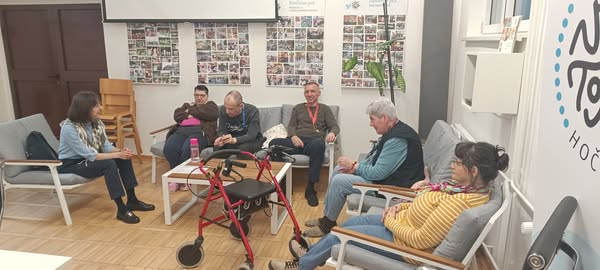 Uporabniki sedijo okrog mize in se pogovarjajo.