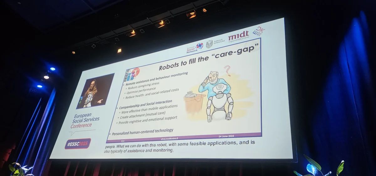 Predavanje na ESSC 2025 z naslovom “Robots to fill the ‘care-gap’”, kjer govorka razlaga o vlogi robotov pri spremljanju, čustveni podpori in zmanjševanju stresa v oskrbi.