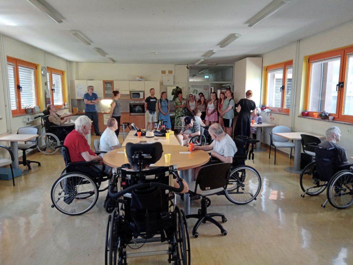 Na sliki so študenti in uporabniki v prostorih VDC Tončke Hočevar, ki sedijo za mizo.