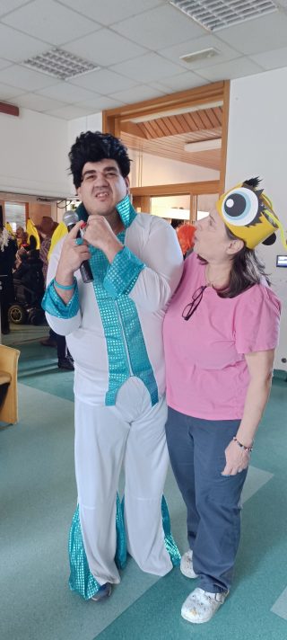 Slika varovanca VDC Tončka Hočevar v pustnem kostumu Elvis Presley s pomočnico