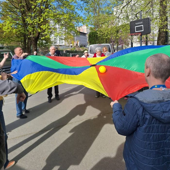 Varovanci VDC Tončke Hočevar igrajo igro z žogico in marvično plahto