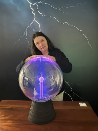 Ženska v rokah drži kroglo za poskus z elektriko v Tehnoparku Celje