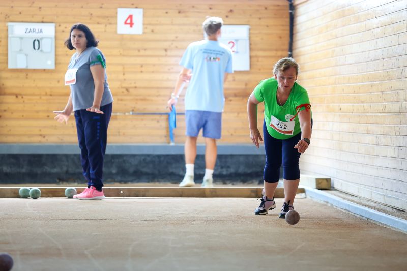 Tekmovalka meče balinarsko kroglo med tekmovanjem v dvorani.