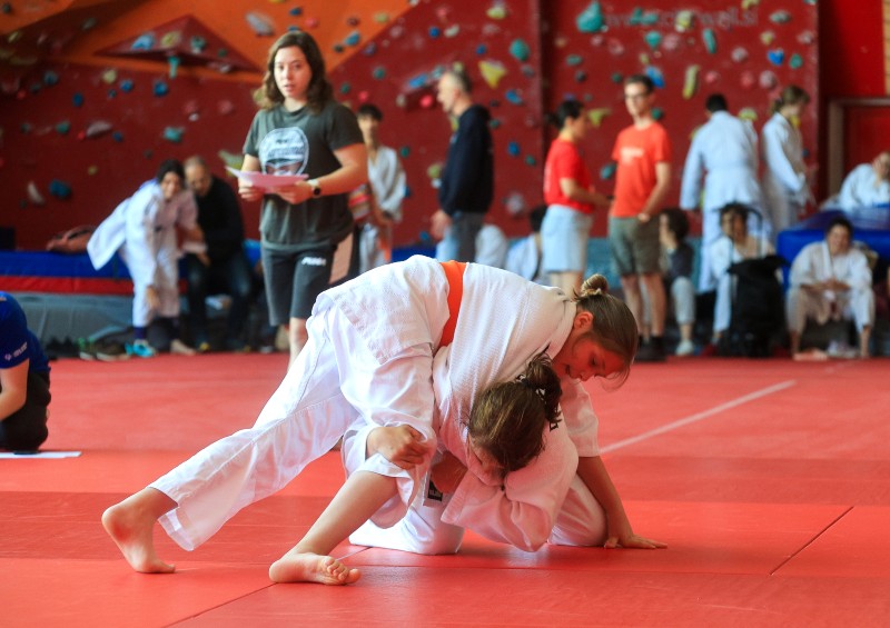 Tekmovalca izvajata judo prijem med tekmo na blazini.
