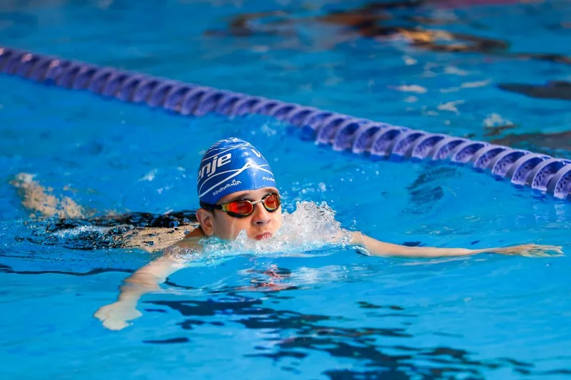 Tekmovalec plava prsno disciplino v bazenu med tekmovanjem na 20. poletnih državnih igrah Specialne olimpiade Slovenije v Ljubljani.