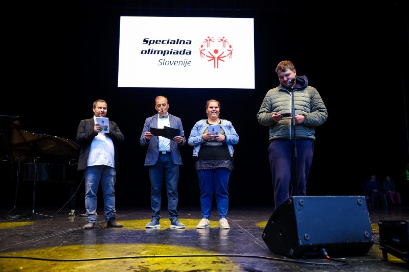 Udeleženec bere zaprisego športnikov na odru ob odprtju iger.