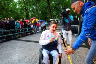 Športnik prižiga olimpijski ogenj na otvoritveni slovesnosti iger.