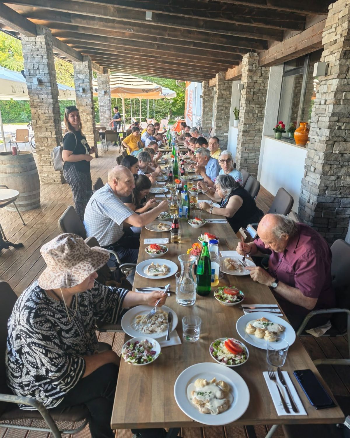 Udeleženci praznovanja Dneva VDC-ja so zbrani za skupnim kosilom na terasi Gostilne Livada.