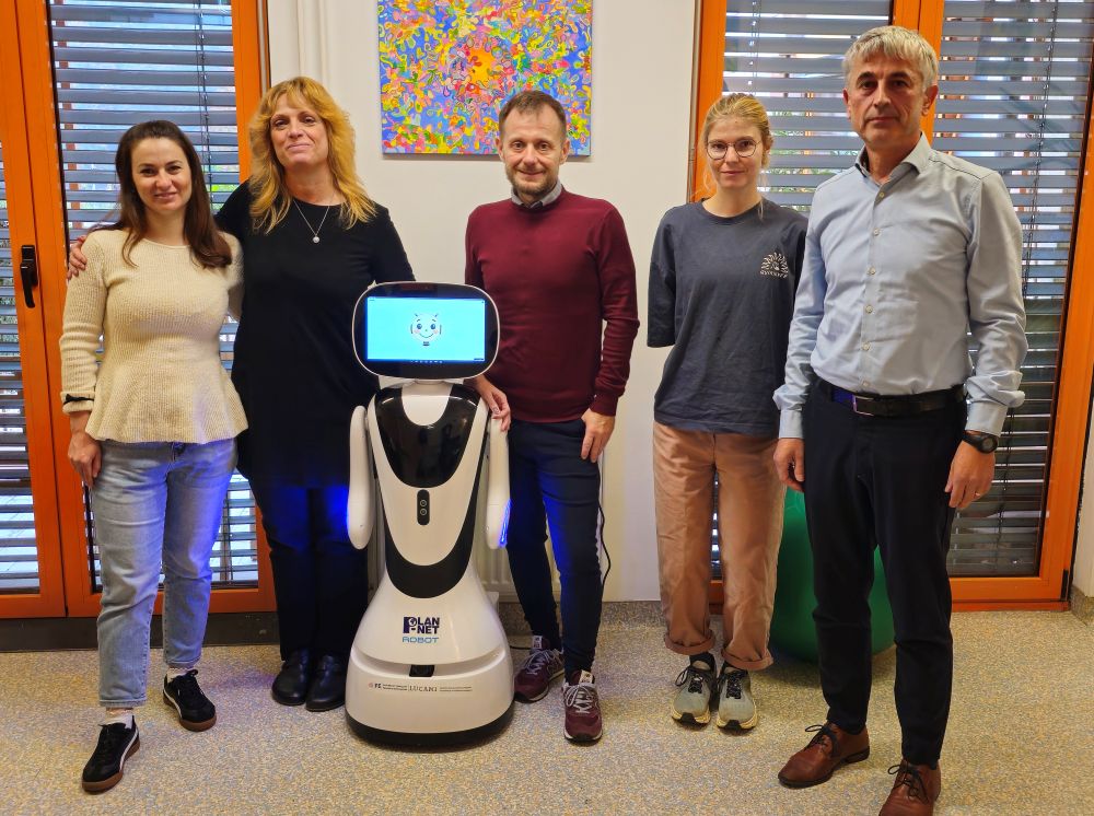Predstavniki VDC Tončke Hočevar in Fakultete za elektrotehniko Univerze v Ljubljani ob socialnem robotu Timu, ki ga razvijajo za podporo osebam z motnjo v duševnem razvoju.