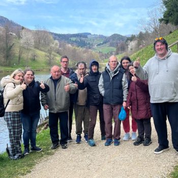 Varovanci VDC Tončke Hočevar na sprehodu pozirajo ob jezeru