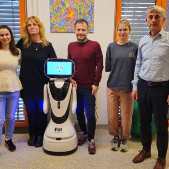 Predstavniki VDC Tončke Hočevar in Fakultete za elektrotehniko Univerze v Ljubljani ob socialnem robotu Timu, ki ga razvijajo za podporo osebam z motnjo v duševnem razvoju.