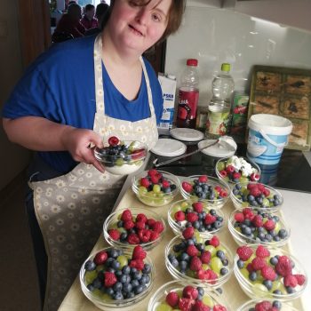 Naša varovanka Tina servira sadje v skodelicah z jogurtom. Zdravo in okusno.